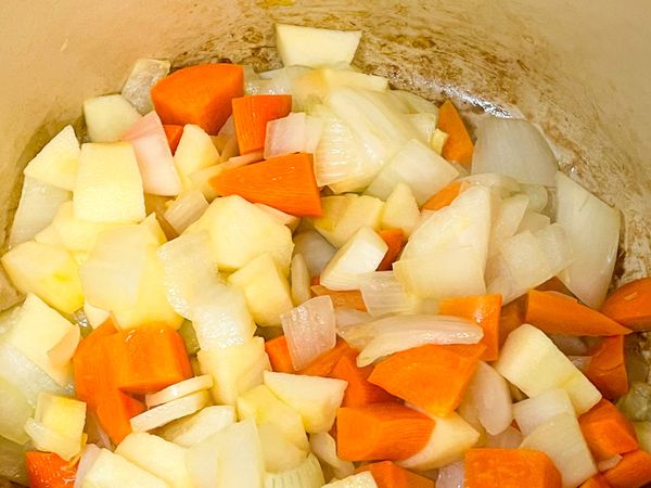 冷鍋下橄欖油，爆香大蒜、洋蔥，炒到半透明後加入紅蘿蔔繼續拌炒