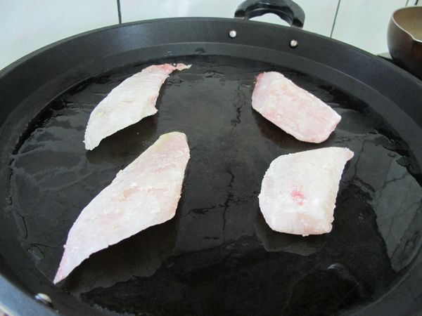 醃好的魚片均勻拍上一層麵粉,取一平底鍋,加入少許油,下魚片