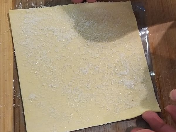 拿一片酥皮灑些砂糖，邊角抹少許的水