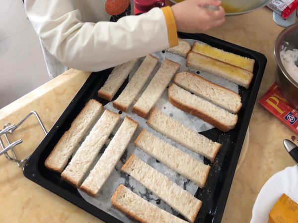 1-融化奶油加入一些蜂蜜或楓糖漿拌勻，若使用無鹽奶油可加入少許鹽提味
2-吐司切條，平鋪於烤盤下襯烘焙紙 
3-烤箱預熱180度，將（1）均勻塗抹在吐司上，單面即可。用手捏取少許砂糖灑在上面，放入烤箱中層5分鐘再移到上層5分鐘