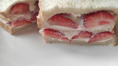 每排完一層就可以再加上土司片再排一層，本作法只使用三片土司，您可以酌量調整層數。將排列完成的草莓厚切奶油土司對切成二份。