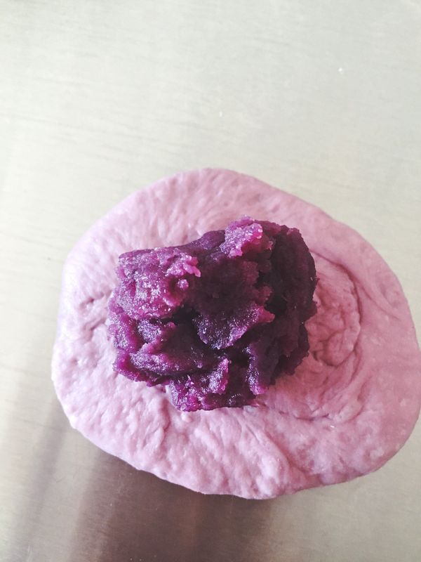 擀開成橢圓面片狀態，包入餡料後捏緊收口。