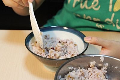 取飯碗盛上煮熟後呈現微紫紅的五穀飯。
