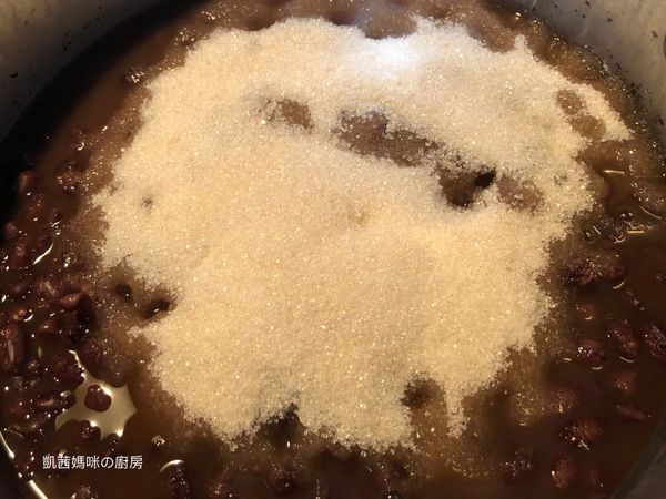 電鍋開關跳起，加糖入紅豆；外鍋加水一杯、鍋蓋緊蓋燜煮至開關再度跳起，蜜紅豆完成。