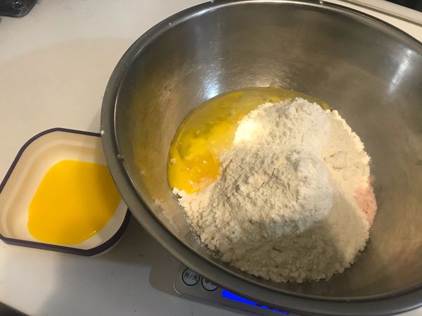 將麵粉、鹽、雞蛋都放人打蛋盆內
另外留一點點蛋黃備用