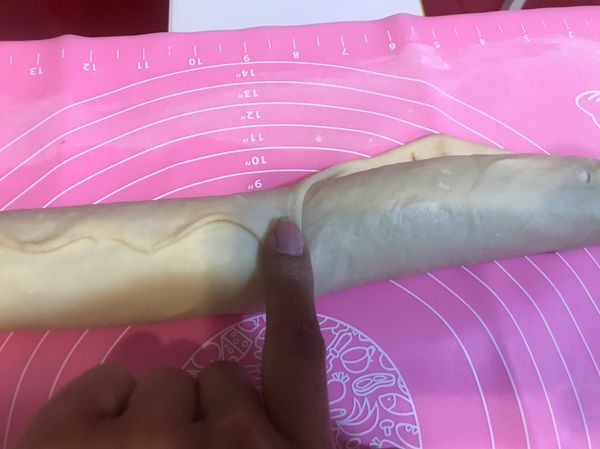 捲到最上面時
用手指將揉麵墊上的麵糰拉起來
黏在肉桂捲上
並且稍微捏合