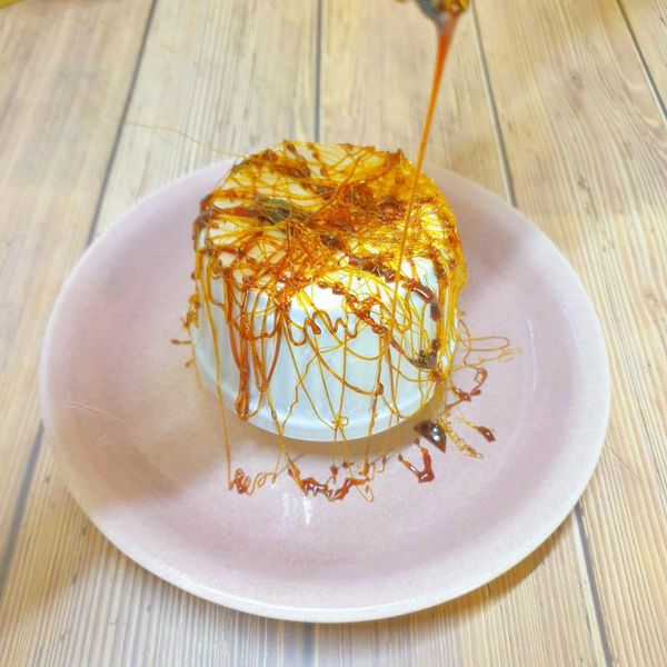 待焦糖半凝固時，用叉子淋細絲在倒置的模具杯上方，懸空的做法是在模具杯內墊入更高的支撐物即可，再用刀子敲掉多餘的底部。