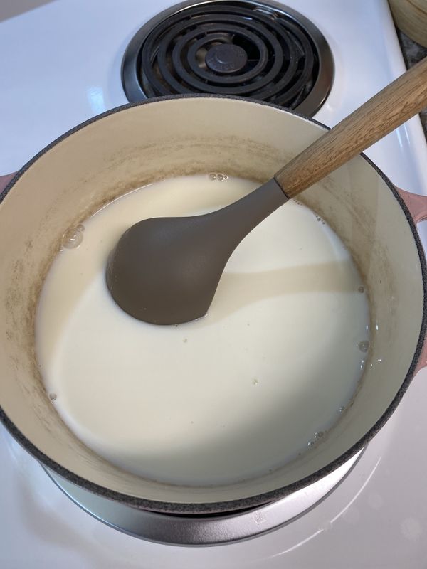 開中火將鮮奶倒入鍋中，並放入砂糖、鹽攪拌均勻。