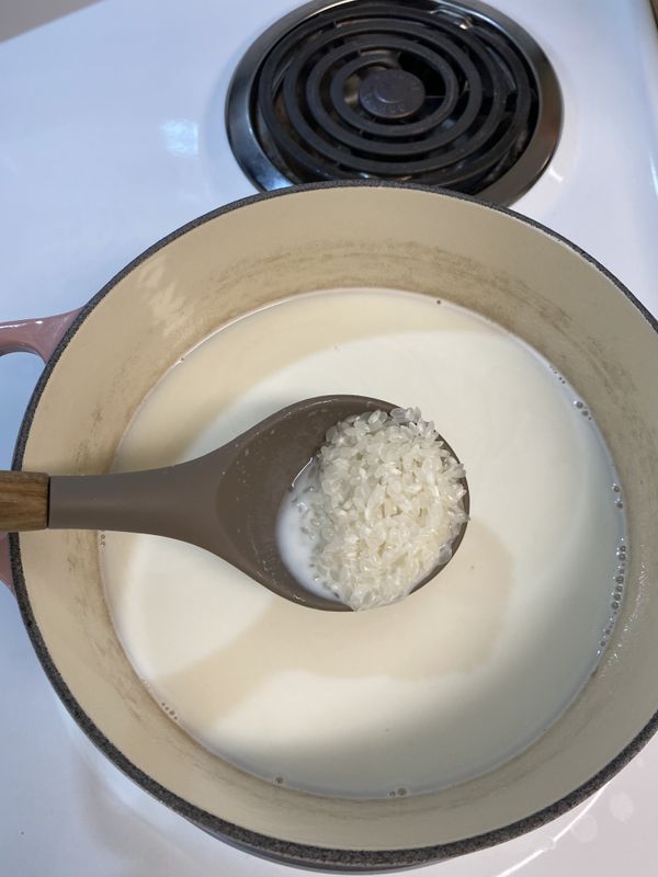 接著把米也倒入，不停攪拌以免沾黏鍋底。