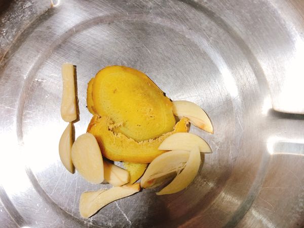 將薑片、大蒜片放在不鏽鋼鍋中間