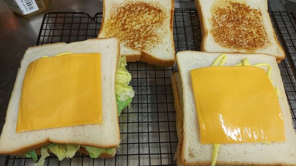 蓋上中間層吐司後在塗蜂蜜芥末醬    放上切達起司片