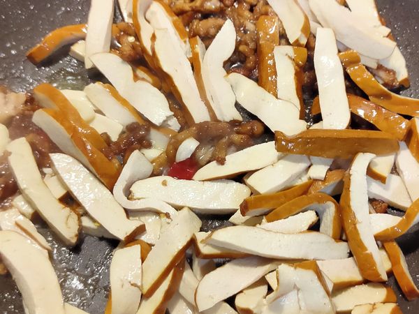 放入豆乾拌炒，加入醬油/米酒調味。