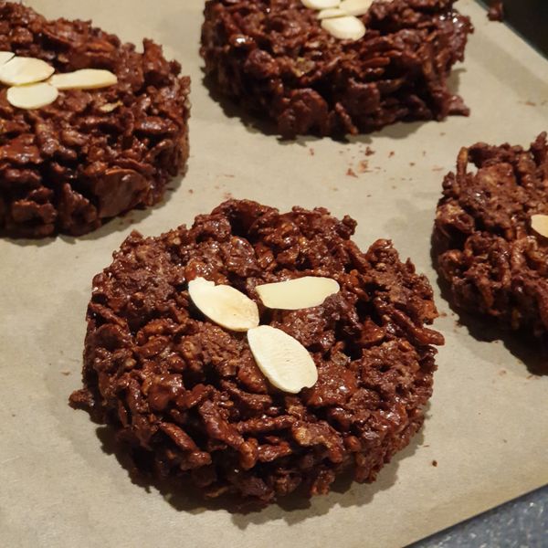 將沾有巧克力的玉米片放入模具中,壓實。
在表面放幾片杏仁片點綴。