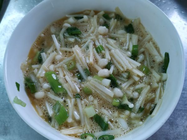 金針菇切小段，蔥切蔥花，雞蛋打入碗中，加入金針菇蔥花還有所有的調味，然後打勻打散