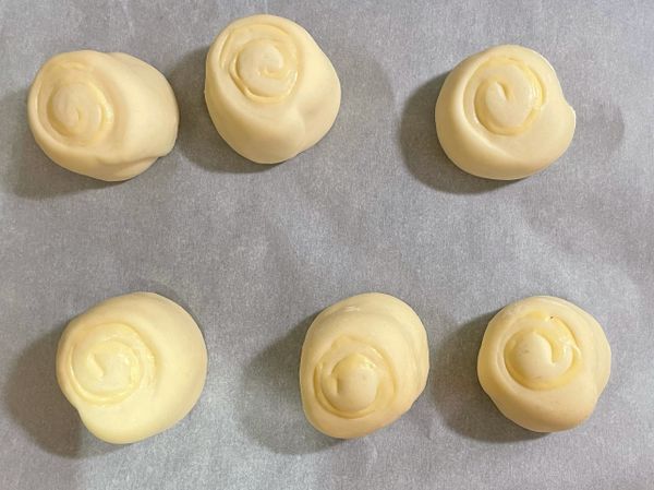 將揉好的麵團分成三等份，一份約60g，在桿成長條狀鋪上起司片，再用硬板對切，這份食譜能做成6顆饅頭