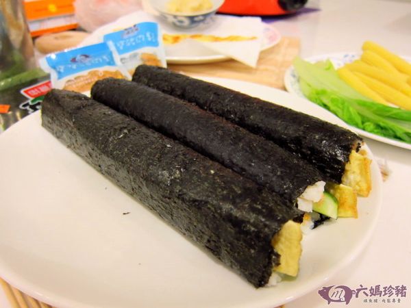 然後，慢慢捲起來～～在海苔最尾端用醋飯抹一下，可黏住海苔哦！