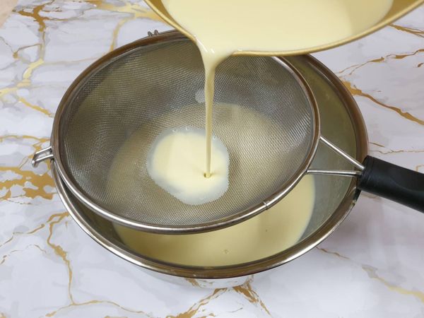 將布丁液用篩網過濾，去除氣泡還有蛋白的黏液，過篩至少要兩次才能讓布丁蒸起來更滑順。