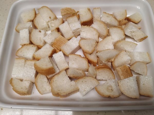 法國麵包切成小塊，放入烤盤中