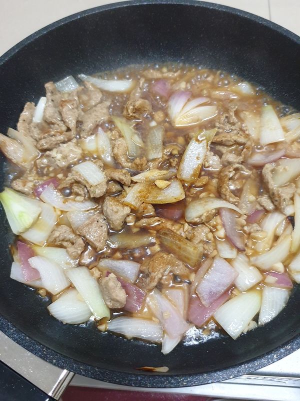 加入熱水、醬油、醬油膏/蠔油、砂糖、黑胡椒粉，蓋鍋燜煮