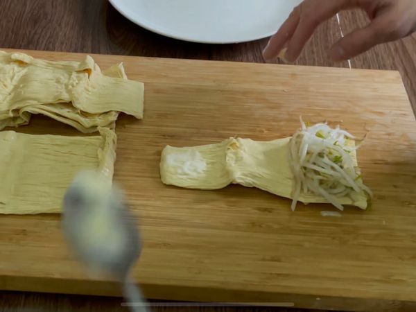 豆包加入豆芽菜，封口處塗上麵糊，卷起來