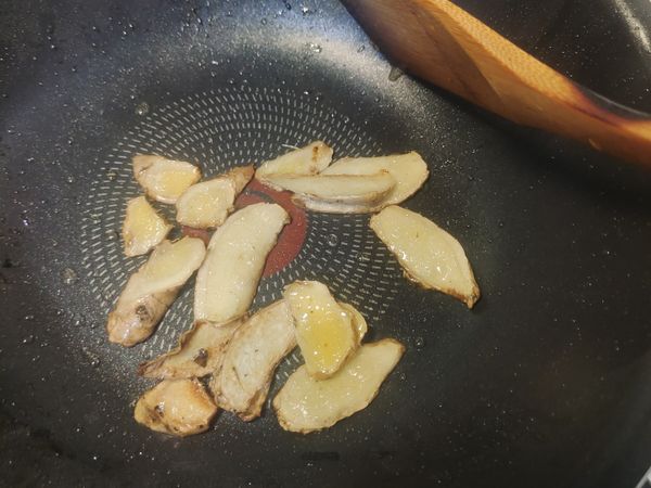 取出煎的金黃的雞腿肉之後, 放入薑片還有1t的葵花油, 轉小火, 慢慢的煎到薑片金黃香氣四溢。