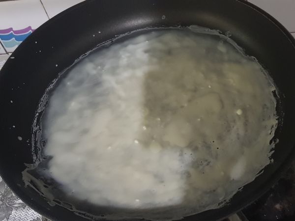 用刷子，把麵粉水，刷在平底鍋上。