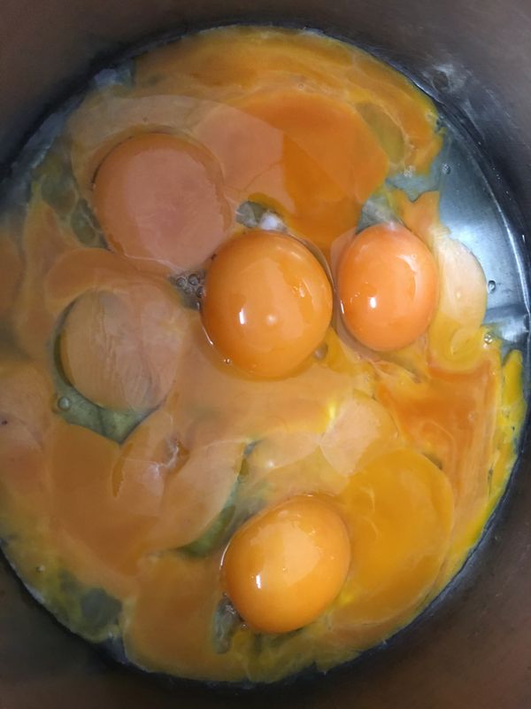 九顆雞蛋取蛋黃加入融化的奶油乳酪糊中迅速用蛋抽打勻，動作要快。蛋白放進冰箱待用。