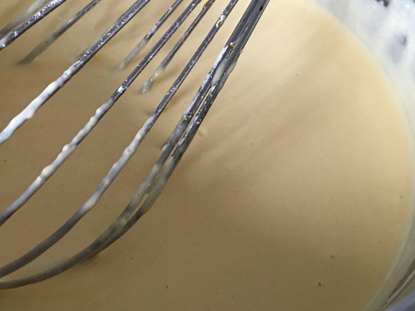 接著過篩，把沒有辦法完全融化的各種顆粒去除，變成均勻的奶油乳酪糊。關火用餘熱再過篩入麵粉， 快速攪拌均勻。這邊部分建議都用蛋抽，攪打速度才會快。