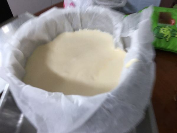 烤箱預熱120度10分鐘，在最底部放一盤熱水，可以用剛剛隔水加熱的熱水。在熱水上層放烤網，然後把模具鋪烘焙紙倒入做好的麵糊麵糊。可以從高處倒入可以看見綿密細緻的麵糊可能也比較不容易有泡泡。放進在烤網上，120度烤60分鐘，拿出來檢查用筷子或竹籤插入試試看可能會有微微沾黏。