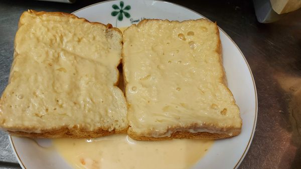 將蛋奶液調好之後將吐司放到裡面浸泡   二面都要沾裹到蛋奶液