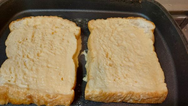 無鹽奶油先放一半進鍋中   接著先將吐司一面煎熟上色