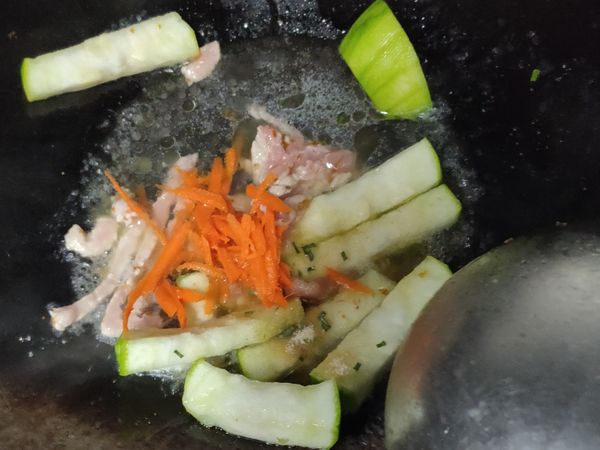 起鍋加入肉燥油包先放入絲瓜和肉絲，胡蘿蔔絲炒熟後。