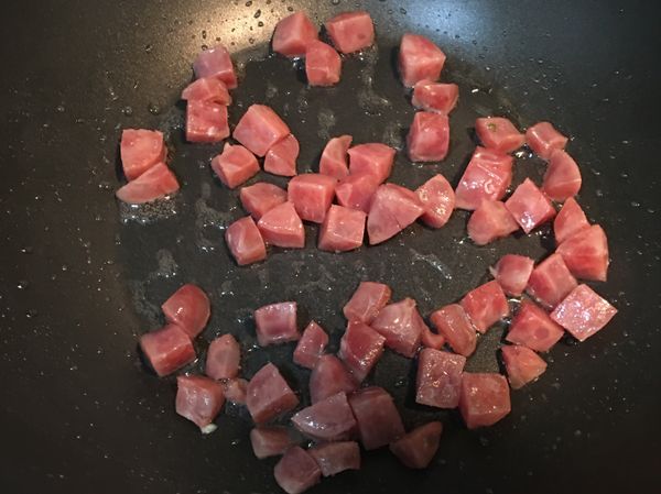 用炒蛋的鍋子，再加少許油，先炒香腸丁。