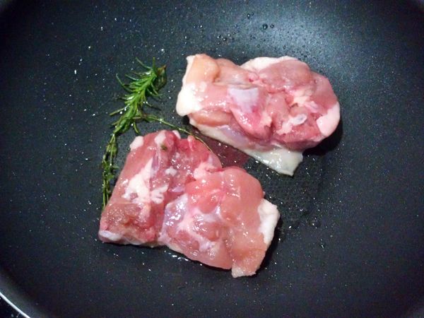 先將材料A的葵花籽油與香草先用小火加熱再放入材料B的雞腿排(沒有香草可用一小辦蒜頭替代)