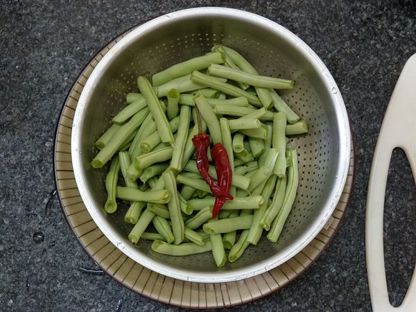 四季豆頭尾折一點點撕下中間的硬梗，再折斷成適當長度和辣椒一起洗乾淨備用。