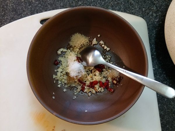 1.燒一鍋熱水。
2.準備一個大碗公，將蒜頭切成蒜末，辣椒用開水湯過後切成小段，放進碗裡。
3.加入食用油、麻油、鹽、糖、少許米酒調味。