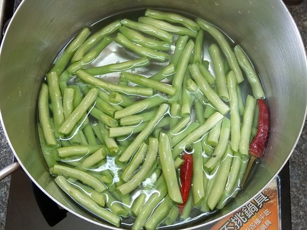 水燒開後放四季豆下去煮，等到水滾豆子顏色稍微變深就可以撈起。