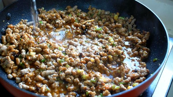 放入一半蔥花、豆豉拌炒均勻，加200cc水煮開