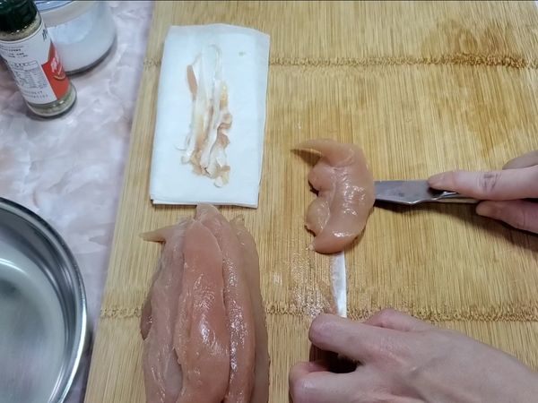 雞里肌清洗並擦乾，去筋。
👉去筋能讓口感更好。
👉去筋：白色筋和肉相連的最前端先劃開，左手壓著白色筋，刀子以水平的方式平移至雞肉末端即完成。