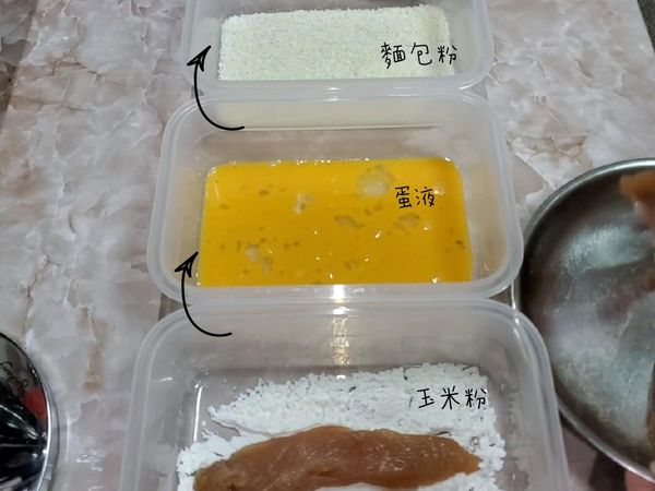 醃漬完成的雞里肌，每一條依序沾附玉米粉、蛋液、麵包粉，沾完麵包粉時，可用雙手稍微壓一壓，幫助粉的附著。