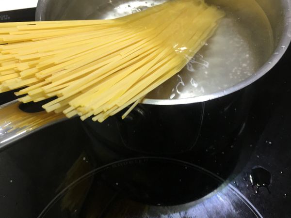 一邊拌炒一邊注意水開後加入一些鹽再放入義大利麵煮（包裝上標示煮9分鐘口感彈牙）