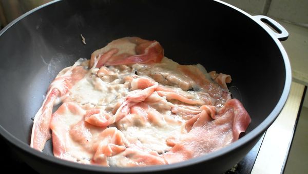 熱鍋加油，豬肉片鋪底