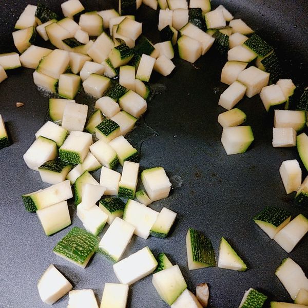 接著倒入沙拉到鍋子裡，再將櫛瓜丁放入拌炒一下放涼備用。