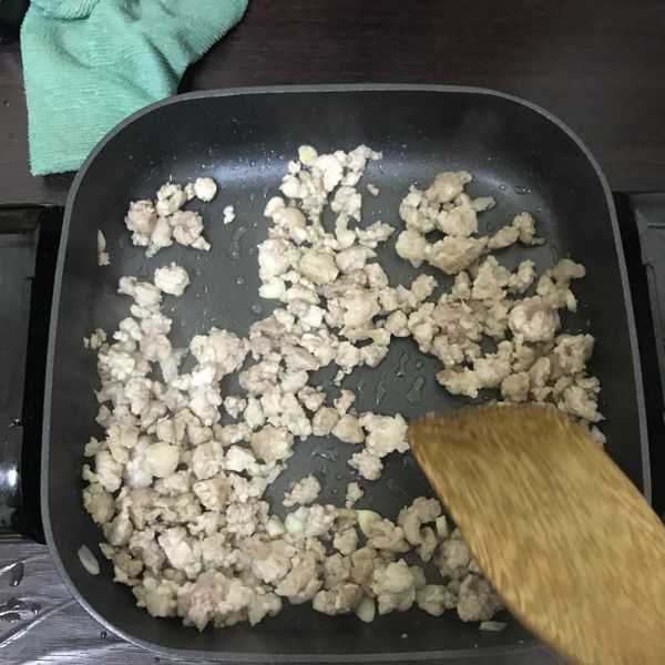 煎好蛋的電烤盤，直接下蒜末炒香，放入絞肉，炒至變白色。