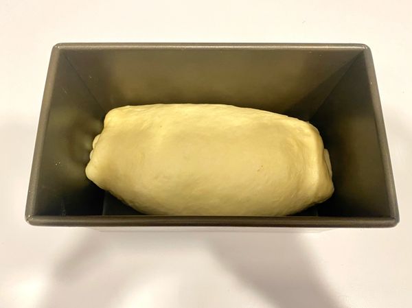 桿捲入烤模，最後發酵30分鐘，麵團達烤模8分滿