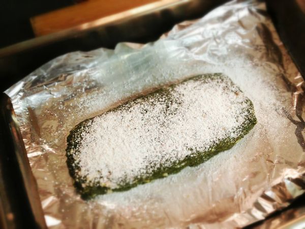 烤盤中鋪上鋁箔紙，將麵糰放上鋁箔紙，捏成厚度約2cm、寬度8cm的長條形，在表面撒上大量的糖粉，入烤箱烤25分鐘。