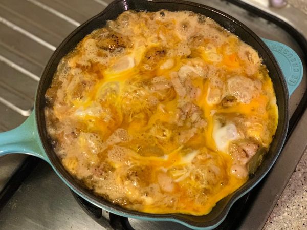 繞圈方式倒入約1/2-2/3的蛋液，蛋白熟（變白）後再倒入剩下的蛋液、依喜歡的熟度熄火，雞肉親子鋪至白飯上、加上喜歡的配菜就完成囉。