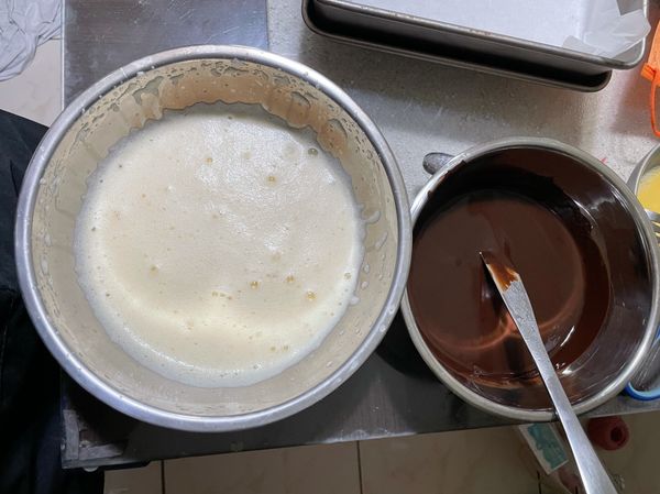 將奶油巧克力醬和蛋黃糊進行攪拌，烤箱先預熱上下層170度