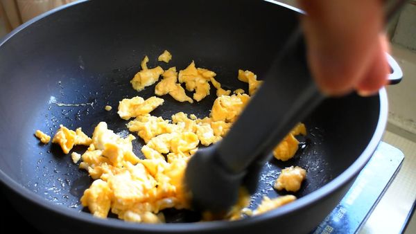 熱鍋加油，到入蛋液炒至全熟且粒粒分明後取出