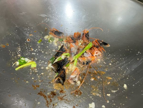 鍋子不用洗，直接下一點油，加入蒜末和蔥花及蝦頭殼